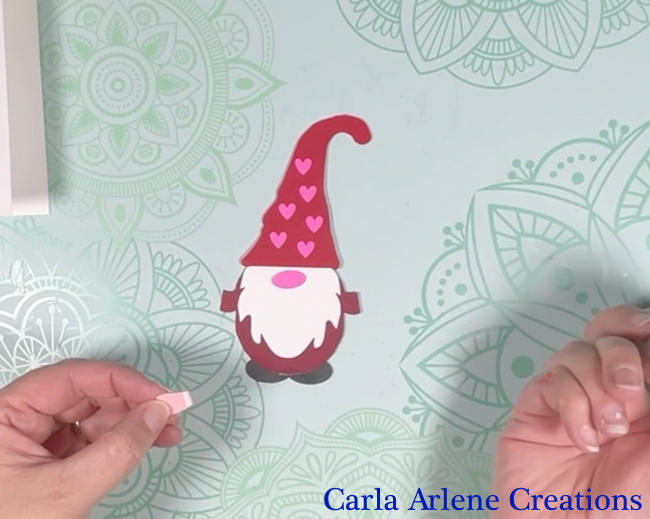valentine gnome card putting glue on back of hand